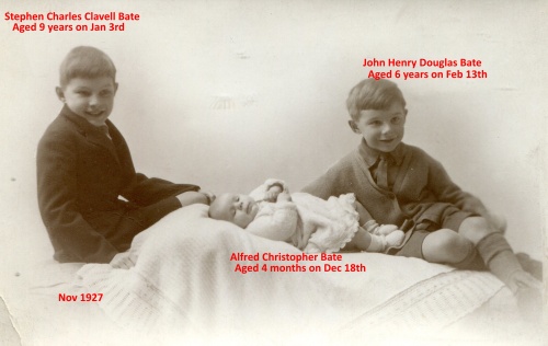 Three children in a studio shot two older boys are shown flanking a baby