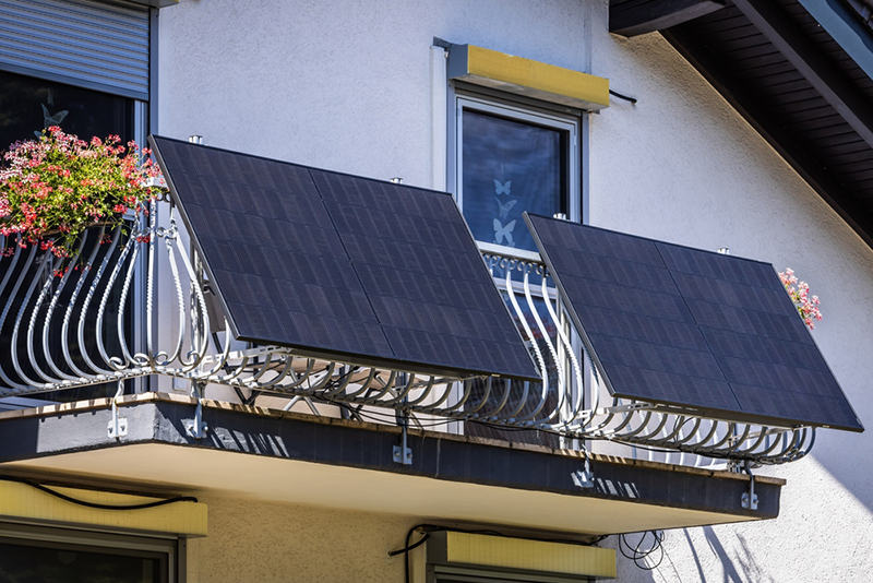 Balcony with two solar panels and a windowbox of flowers