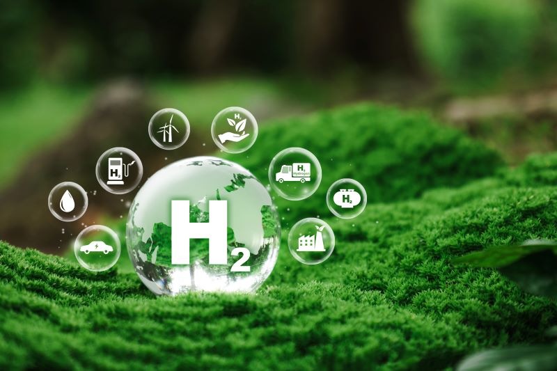 Bubbles containing the hydrogen chemical symbol and icons showing its uses over a green undulating background
