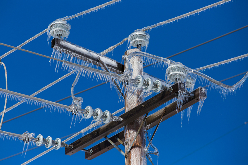 Icicles hanging from an electric pole and wire 