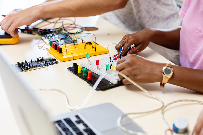 Stock image of students working with electronics