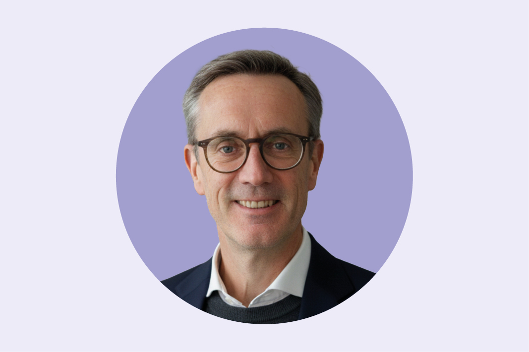 Male in glasses against a purple background