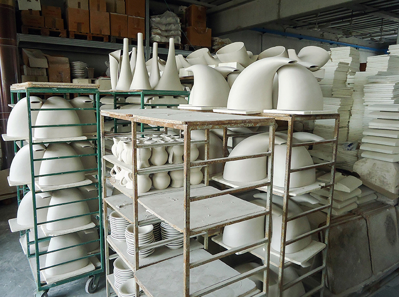 Ceramic pots and plates piled high on shelves