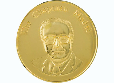 Gold circular medal, raised letterine at the top reads The Chapman Medal, below is an image depicting Chapman looking ahead
