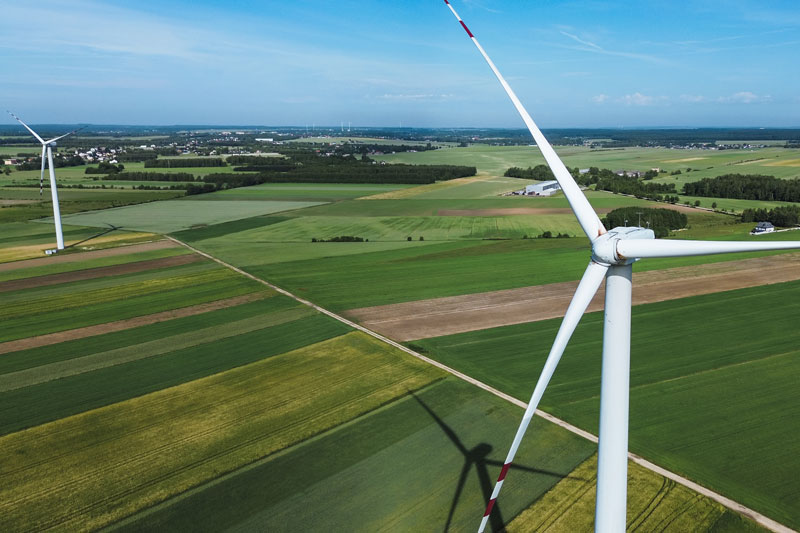 A wind turbine in a landlocked area with greenery