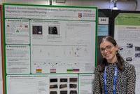 A poster presentation with a smiling female standing next to the posterboard
