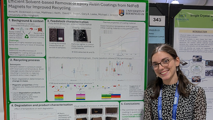 A poster presentation with a smiling female standing next to the posterboard