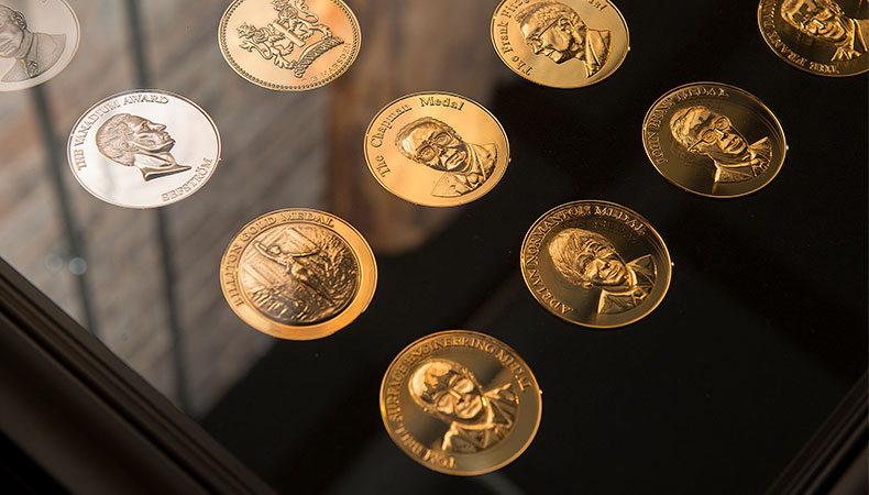 angled view of display case of IOM3 medals, three rows are visible leading off to the top right corner