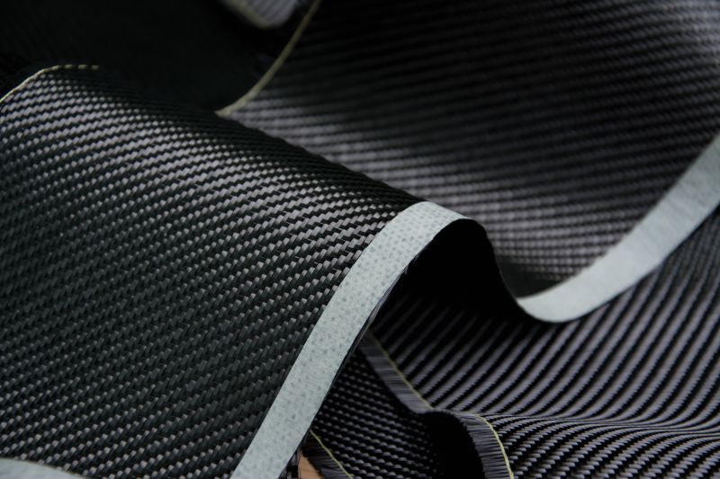 black textured material with grey adges laid in waves on a flat surface