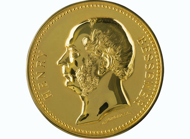 Gold circular medal with a left facing side profile of Bessemer, raised lettering reads Henry to the left of the image and Bessemer to the right