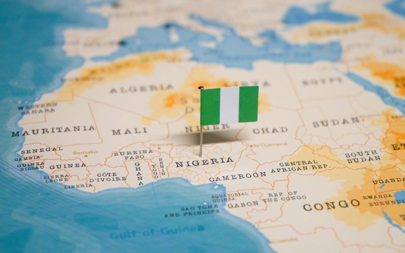 Cities in countries like Nigeria need greater study in the field of climate science to represent the global journey to net-zero. Flag of Nigeria pinned in a map of the region surrounding Nigeria in Af