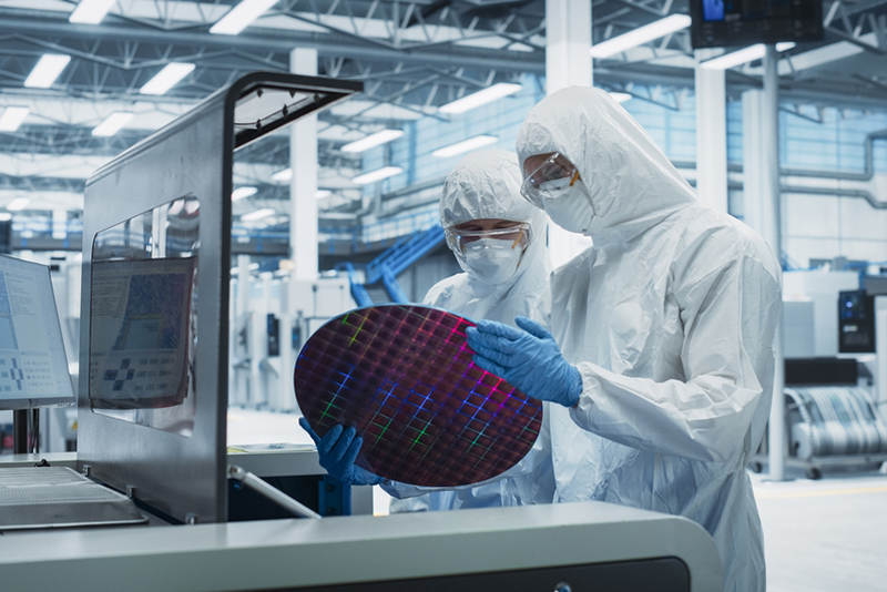 Electronics Manufacturing Facility: Two Specialists In Sterile Suits  examining computer hardware