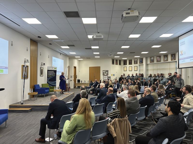 speaker in front of large screen and audience