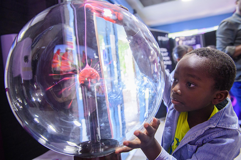 Child with a hands on science exhibit