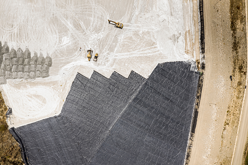 shot from above to show yellow heavy plant and tyre tracks with rock formations