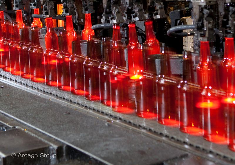 glowing red bottles travelling along a packaging line