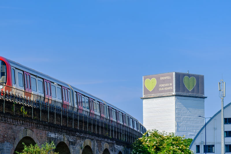 Grenfell tower in the background with a London Underground trail wisible to the left