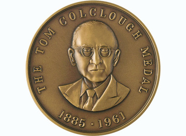 Bronze medal with raised lettering reading The Tom Colclough Medal 1885-1961 and a representation of him centred looking forward wearing glasses