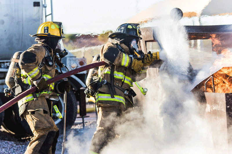 firefighters sprey a white substance