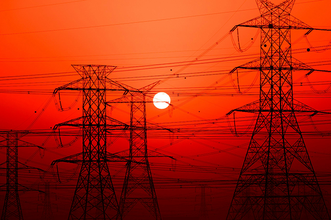 pylons under a red sky with the sun in the background