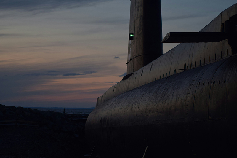 Submarine silhouette with a green light visible on the conning tower