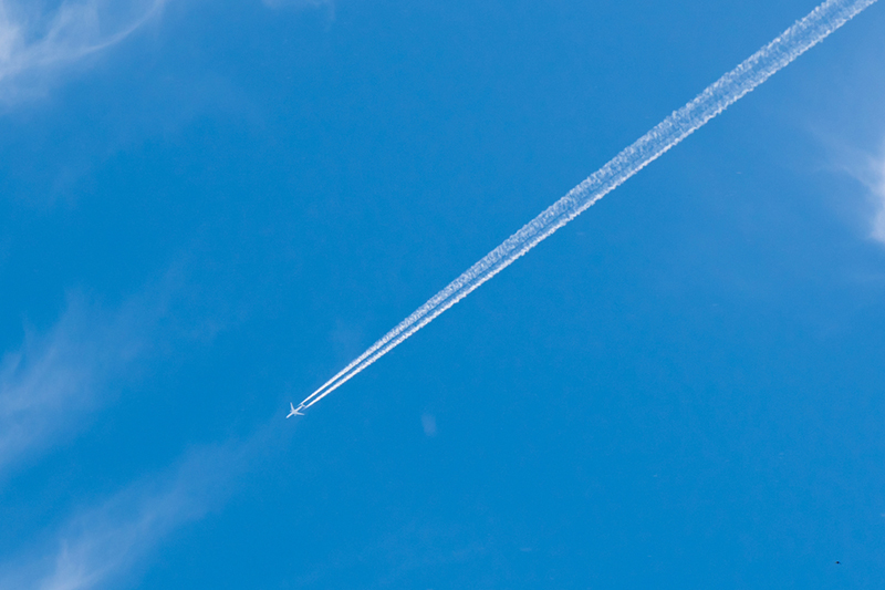 Blue sky with aircraft and vapour trail 