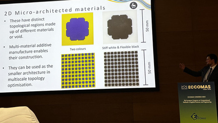 A darkened room with a large screen showing a presentation, speaker to the right