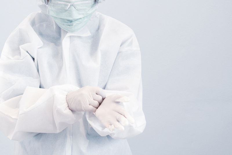 Doctor wearing medical  personal protective clothing - face mask, goggle, coat and gloves