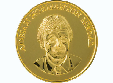 raised lettering reads Adrian Normanton Medal at the top of a gold circulat medal, beneath is a depiction of Normanton