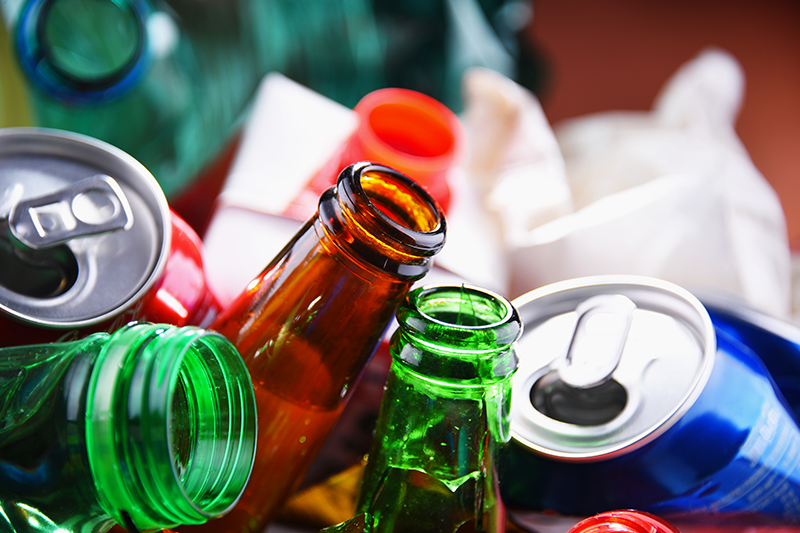 Stock image of a variety of drinks packaging for recycling, with aluminium cans, glass bottles and plastic
