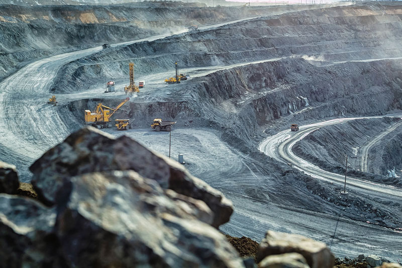 Trucks and excavator in an open mining pit