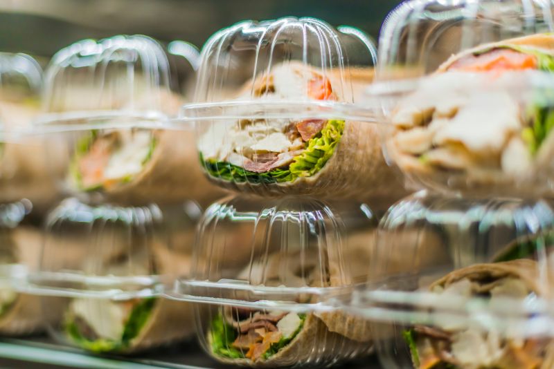 Pre-packaged sandwiches put up for sale in a commercial refrigerator in plastic packaging.
